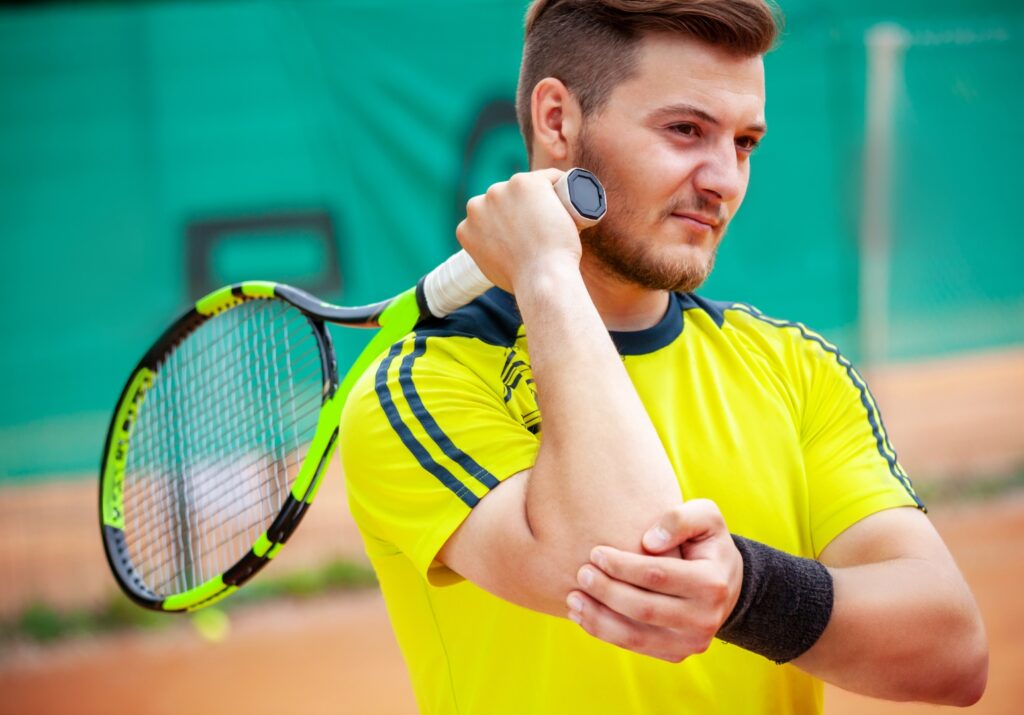 Man with tennis elbow in pain during a match