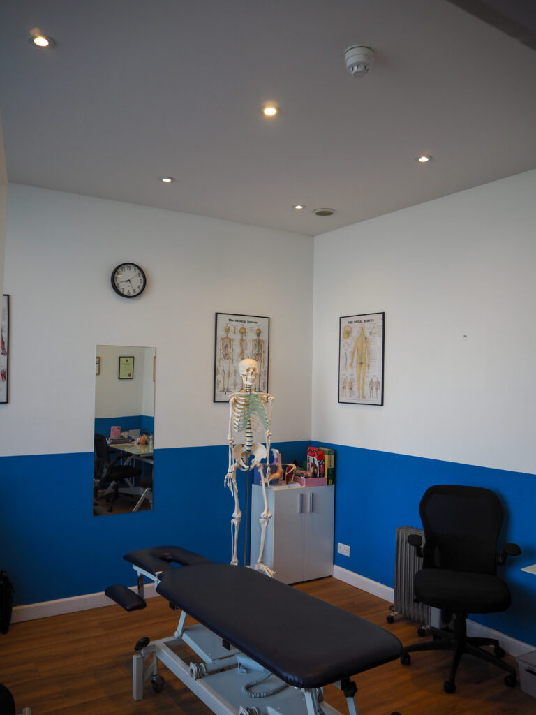 Treatment room in Brighton with massage table and skeleton