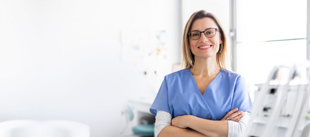 A doctor smiling with her arms crossed